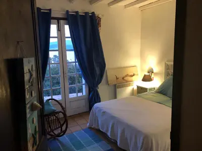 a bedroom with a bed and a window at Maison familiale vue mer in Grosseto-Prugna