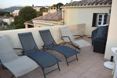 a group of chairs sitting on a balcony at Maison familiale vue mer in Grosseto-Prugna