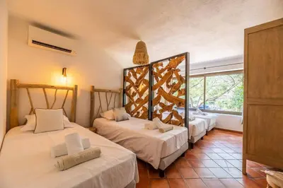 two beds in a room with a window at Villa Rocca Rossa vue exceptionnelle sur la mer in Porto-Vecchio