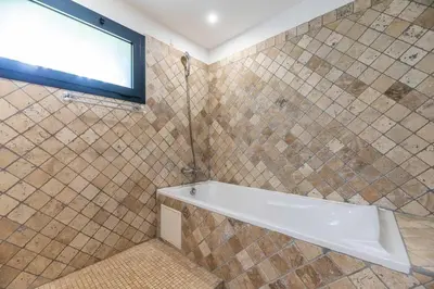 a bathroom with a bath tub and a window at Villa Rocca Rossa vue exceptionnelle sur la mer in Porto-Vecchio