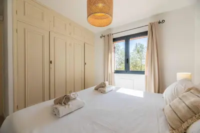 a bedroom with a large white bed with towels on it at Villa Rocca Rossa vue exceptionnelle sur la mer in Porto-Vecchio