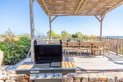 a grill with a laptop on top of it on a deck at Villa Rocca Rossa vue exceptionnelle sur la mer in Porto-Vecchio