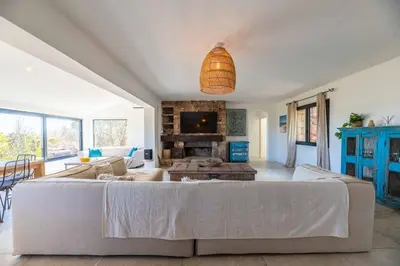 a living room with a couch and a fireplace at Villa Rocca Rossa vue exceptionnelle sur la mer in Porto-Vecchio