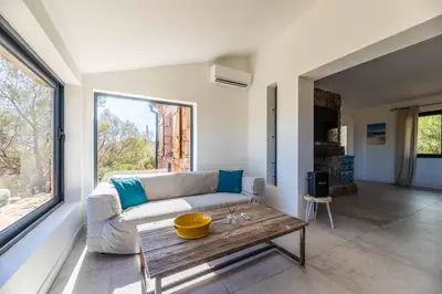 a living room with a couch and a table at Villa Rocca Rossa vue exceptionnelle sur la mer in Porto-Vecchio