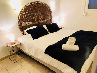 a bed with a headboard and two towels on it at Villa haut de gamme vue panoramique exceptionnelle in Porto-Vecchio