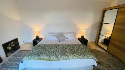 a bedroom with a large bed and two lamps at Villa haut de gamme vue panoramique exceptionnelle in Porto-Vecchio