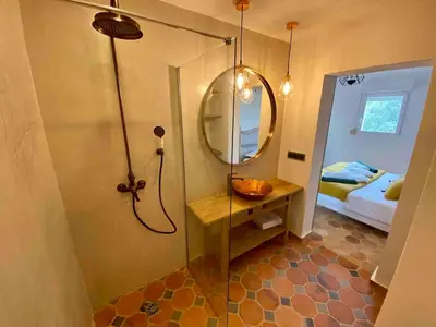 a bathroom with a shower with a mirror and a bed at Villa haut de gamme vue panoramique exceptionnelle in Porto-Vecchio