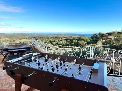 a chess game on a table on a balcony at Villa haut de gamme vue panoramique exceptionnelle in Porto-Vecchio