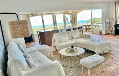 a living room with white furniture and a view of the ocean at Villa haut de gamme vue panoramique exceptionnelle in Porto-Vecchio