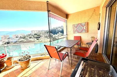 a dining room with a table and a large window at Luminous T3 in the heights of Ajaccio in Ajaccio