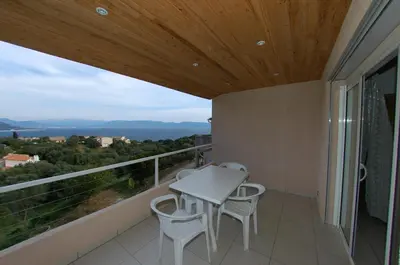 a balcony with a table and chairs and a view at Casa Soprana in Porto Pollo