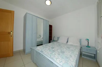 a bedroom with a bed and a blue cabinet at Casa Soprana in Porto Pollo