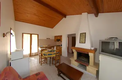 a living room with a television and a dining room at Casa Soprana in Porto Pollo