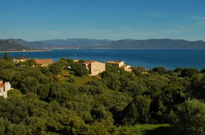 a group of houses on a hill next to the water at Casa Soprana in Porto Pollo