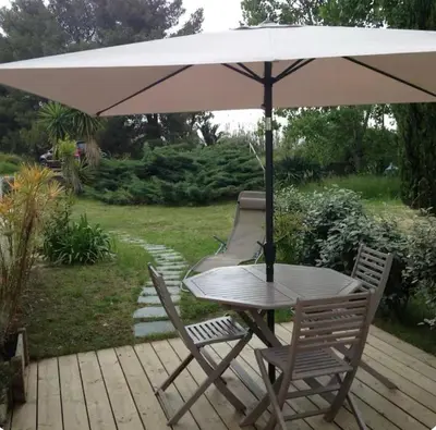 a table and two chairs under an umbrella at Studio entre mer et montagne in Taglio-Isolaccio