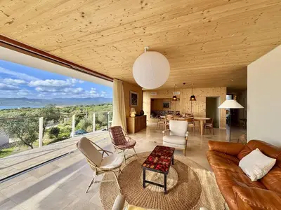a living room with a couch and a table at Villa d'architecte à Abbartello, vue mer et accès plage in Olmeto