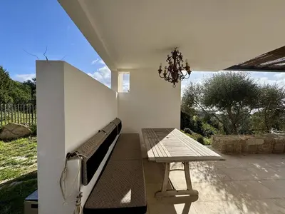 a bench and a table on a patio at Villa d'architecte à Abbartello, vue mer et accès plage in Olmeto