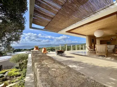 a house with a patio with a view of the ocean at Villa d'architecte à Abbartello, vue mer et accès plage in Olmeto