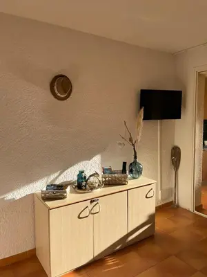 a room with a cabinet with a tv on the wall at T3 climatisé pour 4 à 6 personnes proche mer en Corse in Linguizzetta