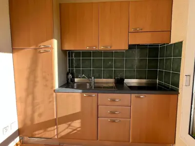 a kitchen with wooden cabinets and a sink at T3 climatisé pour 4 à 6 personnes proche mer en Corse in Linguizzetta