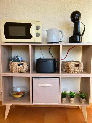 a shelf with a microwave and other items on it at T3 climatisé pour 4 à 6 personnes proche mer en Corse in Linguizzetta