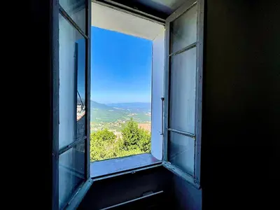 an open window with a view of a mountain at Charmante maison avec vue Idéale pour 4 personnes in Sartène