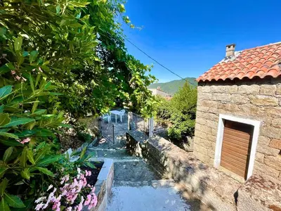 a garden with a small stream in front of a building at Charmante maison avec vue Idéale pour 4 personnes in Sartène