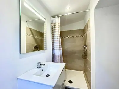a white bathroom with a sink and a shower at Charmante maison avec vue Idéale pour 4 personnes in Sartène