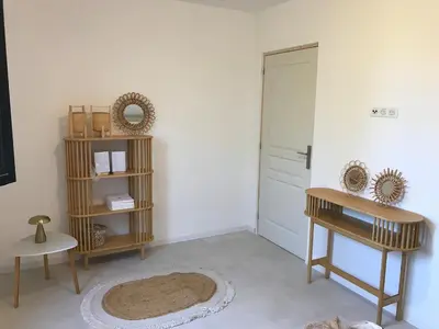 a room with a door and a table and a rug at Isolella à 50 m de la plage in Pietrosella