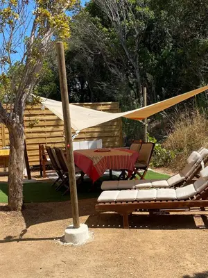 a patio with a table and chairs and a tent at Isolella à 50 m de la plage in Pietrosella