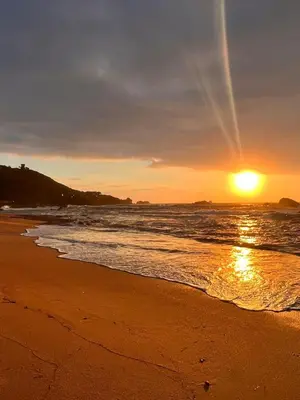 a sunset on a beach with the ocean at Isolella à 50 m de la plage in Pietrosella