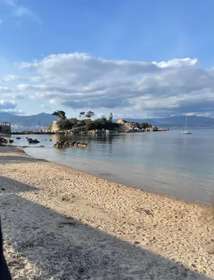 a view of a beach with a boat in the water at Isolella à 50 m de la plage in Pietrosella