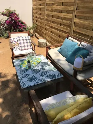a patio with two chairs and a table with pillows at Isolella à 50 m de la plage in Pietrosella