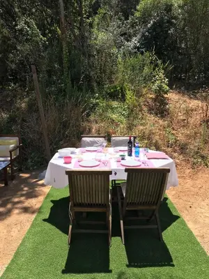 a table with two chairs and a white table with plates at Isolella à 50 m de la plage in Pietrosella
