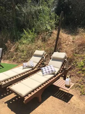 a wooden bench with pillows on top of it at Isolella à 50 m de la plage in Pietrosella