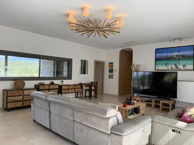 a living room with a couch and a flat screen tv at kaki in Pinarellu
