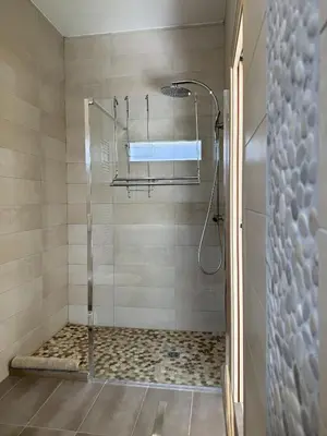 a shower with a glass door in a bathroom at kaki in Pinarellu