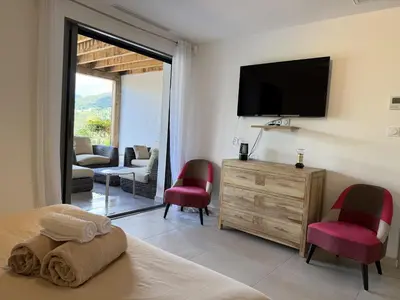 a bedroom with a bed and a flat screen tv at kaki in Pinarellu
