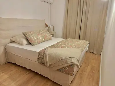 a bed in a bedroom with a wooden floor at Appartement plein centre vue mer PROPRIANO in Propriano