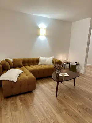 a living room with a brown couch and a table at Appartement plein centre vue mer PROPRIANO in Propriano