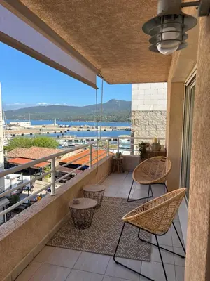 a balcony with chairs and a view of the water at Appartement plein centre vue mer PROPRIANO in Propriano