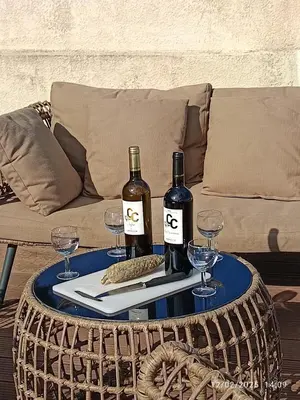 two bottles of wine on a table with wine glasses at Bord de mer, pieds dans l'eau, vue panoramique in San-Nicolao