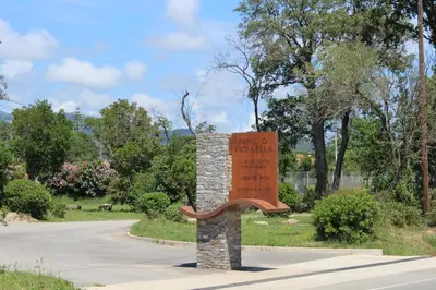 a bench in a park next to a road at Bord de mer, pieds dans l'eau, vue panoramique in San-Nicolao