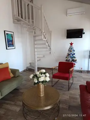 a living room with a staircase and a christmas tree at Bord de mer, pieds dans l'eau, vue panoramique in San-Nicolao