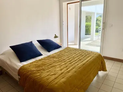 a bedroom with a large bed with blue pillows at ruscana in Pinarellu