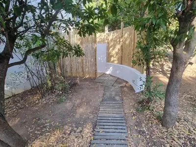 a white bench sitting next to a wooden fence at ruscana in Pinarellu