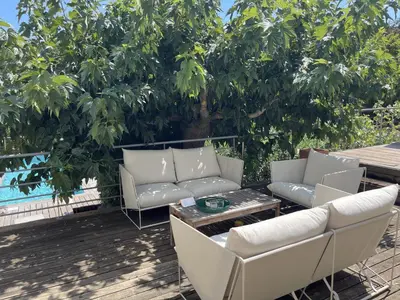 a patio with couches and a table and a tree at ruscana in Pinarellu