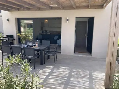 a patio with a table and chairs and a house at tianau in Lecci