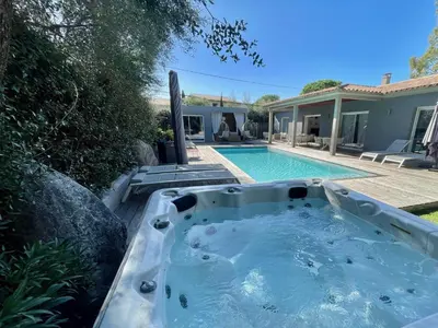 a hot tub in the backyard of a house at meli melo in Pinarellu