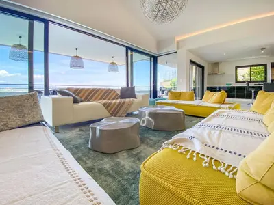 a living room with yellow furniture and large windows at alba in Pinarellu